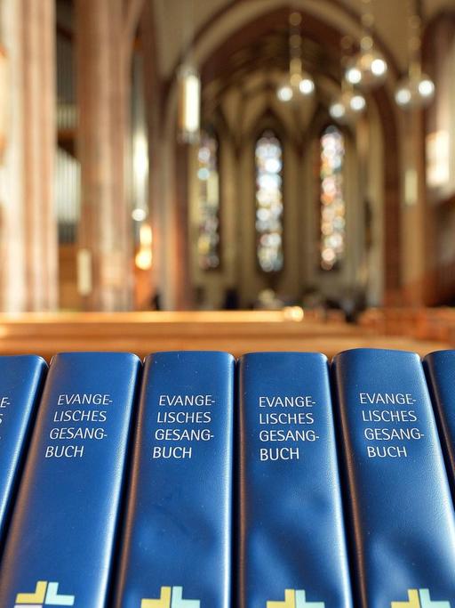 Das Bild zeigt eine Reihe von Evangelischen Gesangbüchern in der Leonardskirche in Stuttgart.