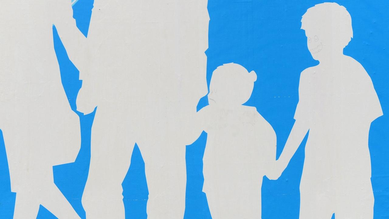 Auf blauem Hintergrund sind die Silhouetten einer Familie mit Mutter, Vater, Tochter und Sohn in weiß zu sehen.