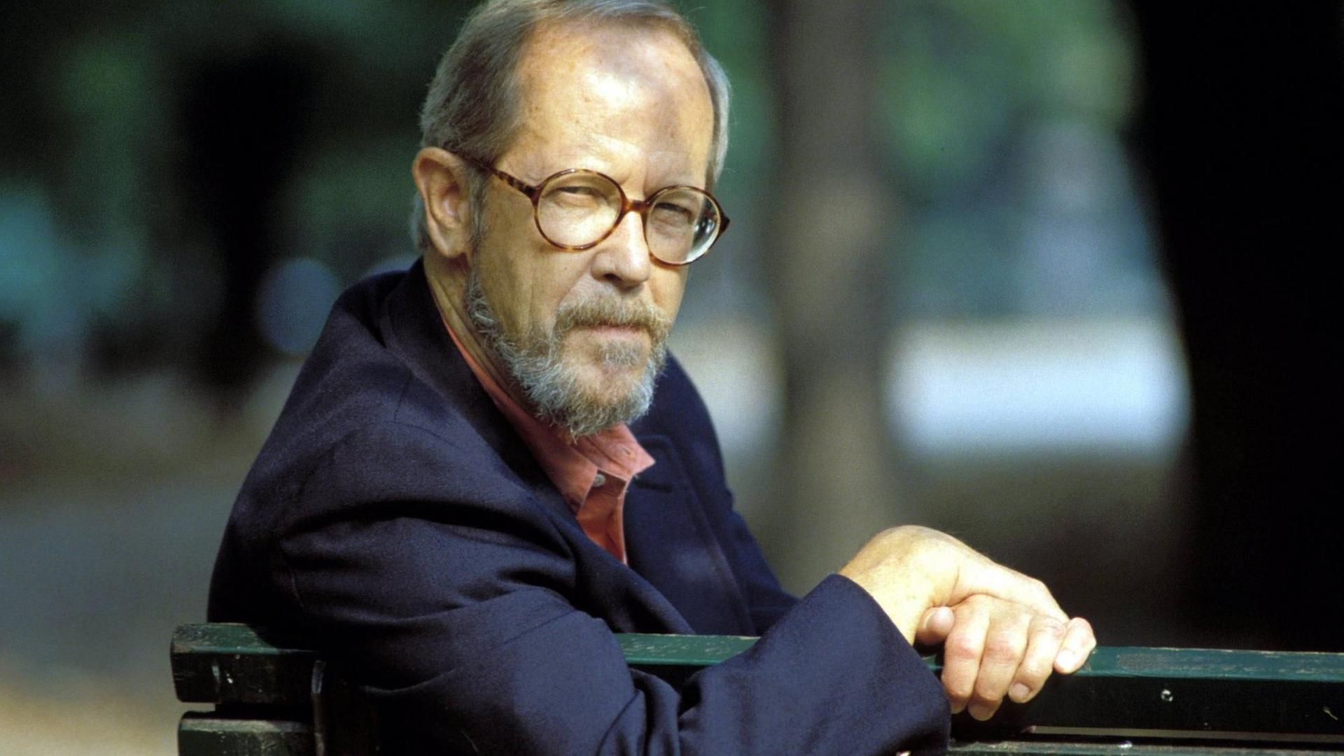 Der Schriftsteller Elmore Leonard sitzt auf einer Parkbank und schaut in die Kamera.