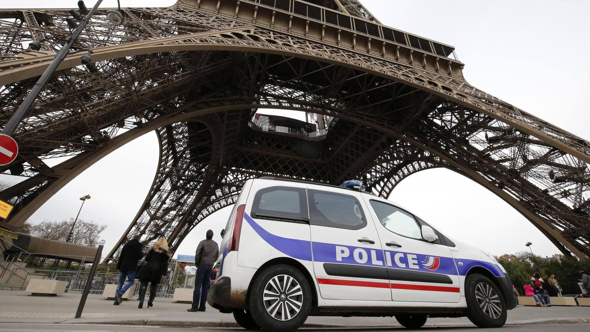 Ein Polizeiauto passiert in Frankreich den Eiffel-Turm.