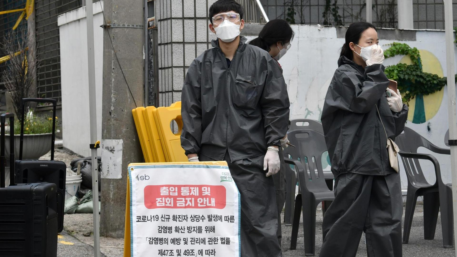 Mitarbeiter des Gesundheitsministeriums stehen vor der Sarang-Jeil-Kirche in Seoul.