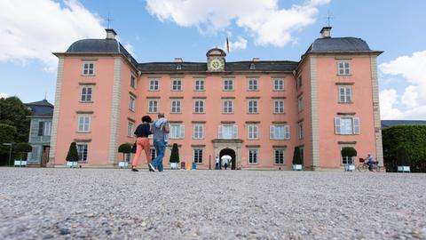 Besucher laufen am 21.08.2014 in Schwetzingen (Baden-Württemberg) am Hauptgebäude des Schlosses vorbei