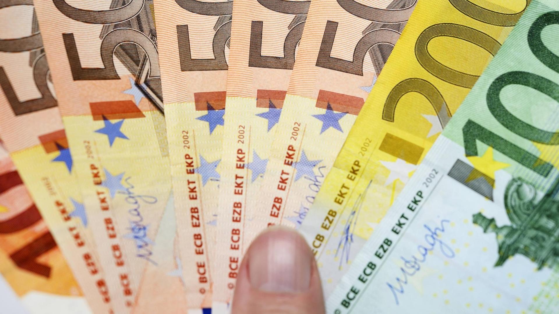 Eine Hand hält Euro-Geldscheinwie einen Fächer. | Verwendung weltweit