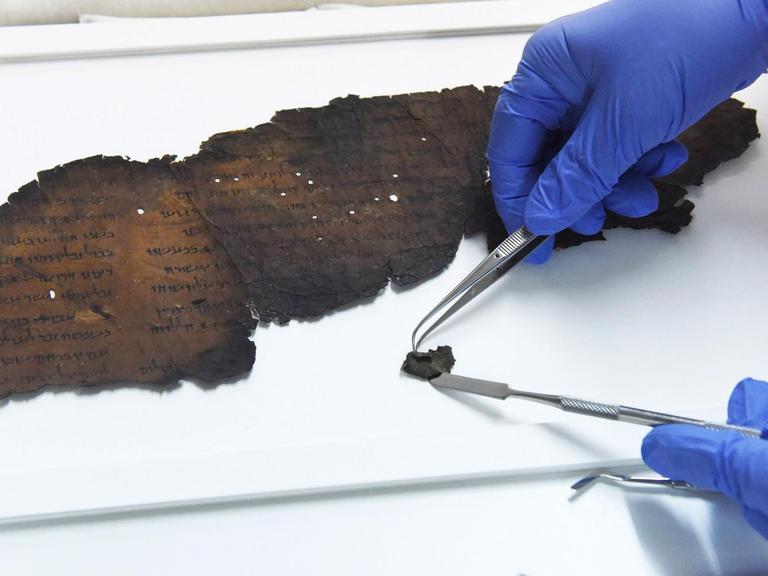 Eine Wissenschaftlerin untersucht Fragmente der sogenannten Schriftrolle von Qumran im Sommer 2018 in Israel.