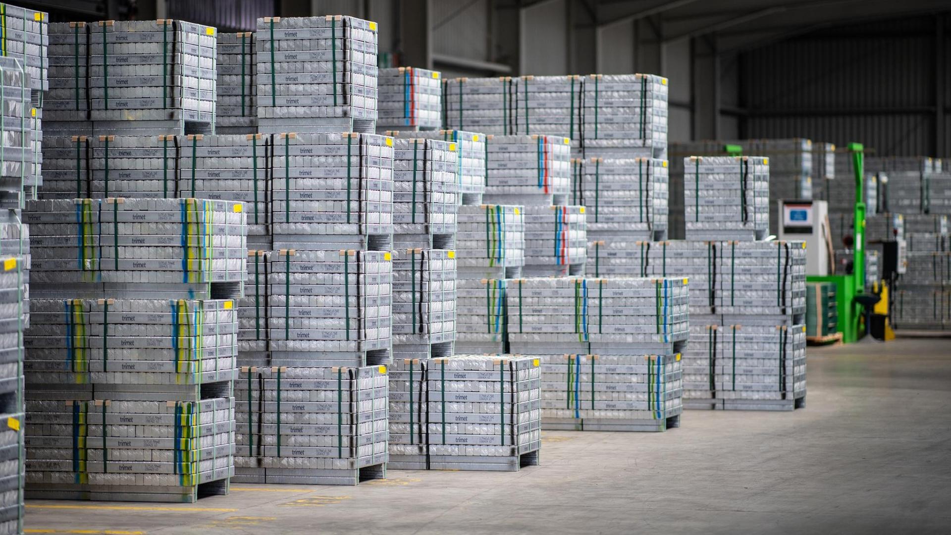 Fertig produzierte Aluminiumbarren stehen zum Abtransport in einem Lager.