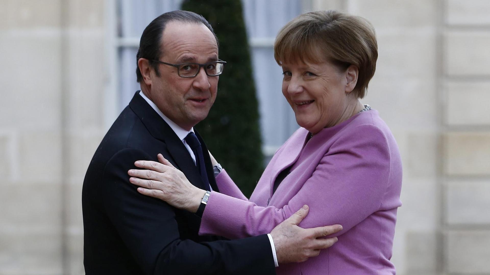 Frankreichs Präsident Francois Hollande und Bundeskanzlerin Angela Merkel begrüßen sich in Paris.