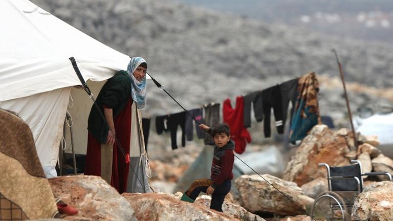 Syrians who fled pro-regime forces attacks in the Idlib and Aleppo provinces are pictured at a makeshift camp for displaced people on February 18, 2020 north of the city of Idlib, near the Turkish border. - A wave of displacement that has seen around 700,000 people flee a regime offensive in Syria's Idlib region is the biggest of the nine-year-old conflict, the United Nations said. (Photo by Bakr ALKASEM / AFP)