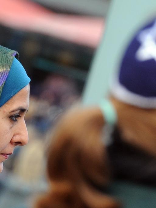 Eine Muslimin mit Kopftuch und eine junge Frau mit Kippa nehmen am Samstag (15.09.2012) in Berlin gemeinsam an einer Demonstration teil.