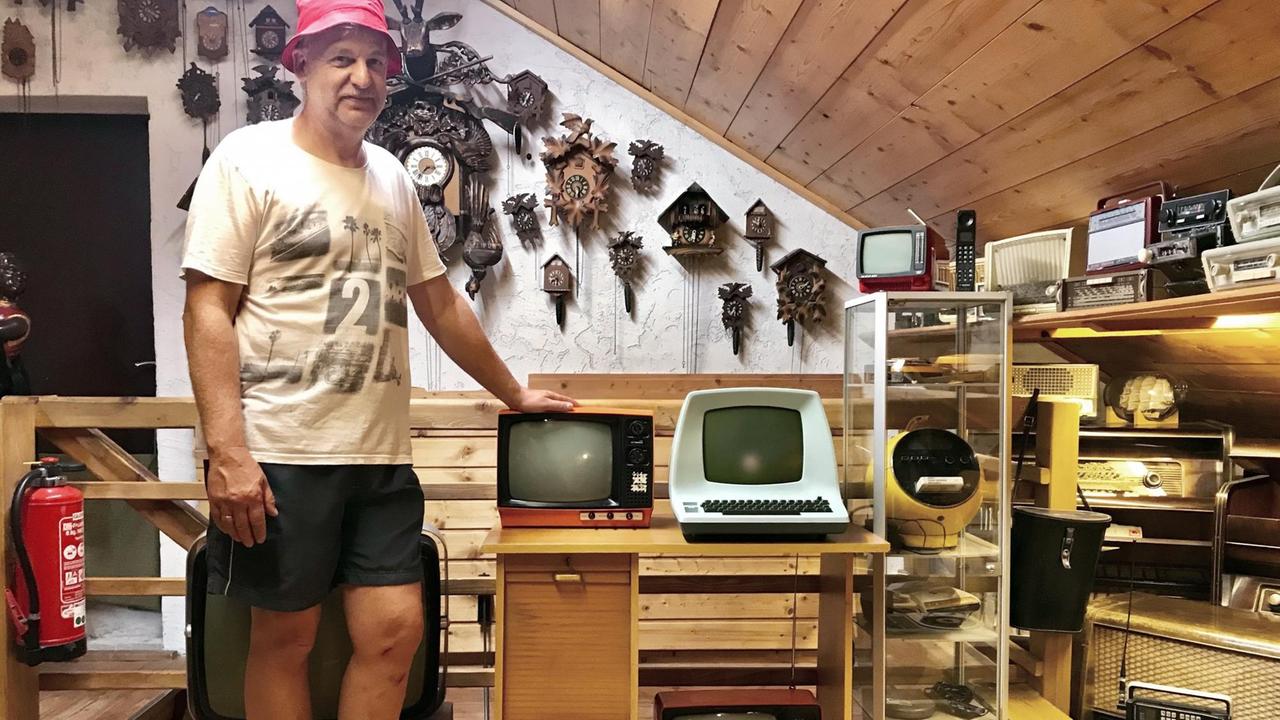 Karl Thomann, der Leiter des Müllmuseums, steht neben seiner Sammlung alter Fernsehgeräte.