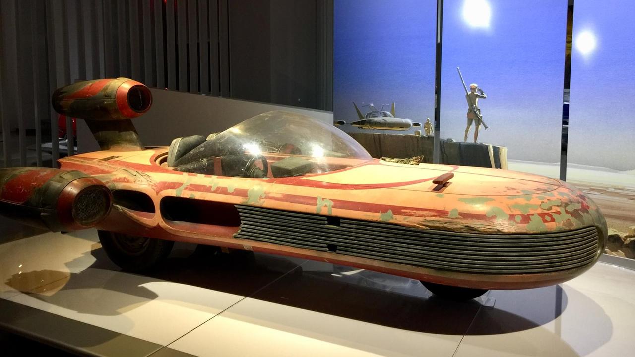 Der X-34 Landspeeder aus dem Film "Star Wars: Episode IV – Eine neue Hoffnung" ist in einer Ausstellung über Autos in Filmen in Los Angeles zu sehen. Es handelt sich um ein längliches Gefährt ohne Verdeck.