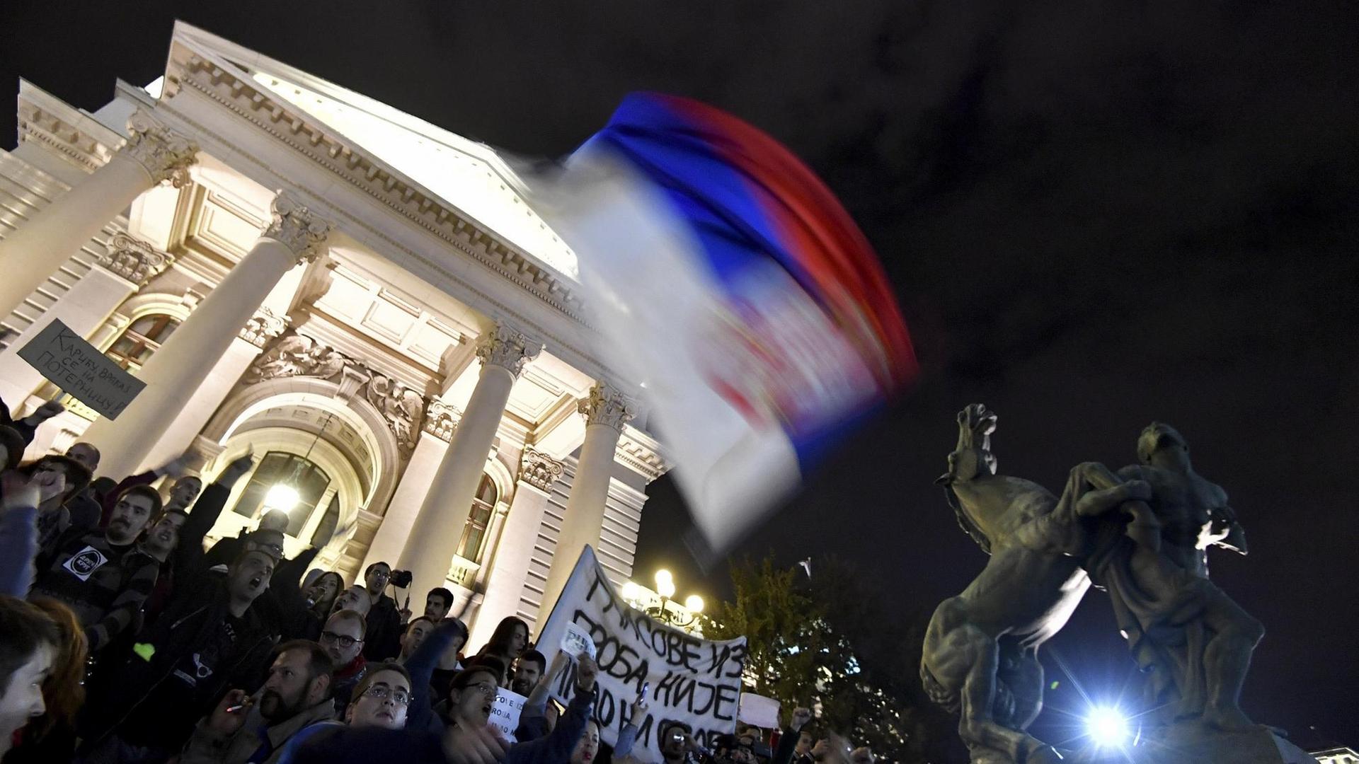 Menschen haben sich vor dem Parlament in Belgrad versammelt und protestieren gegen Ministerpräsident Vucic.