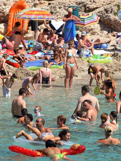 Menschen am Strand von Cala d’Or auf Mallorca.