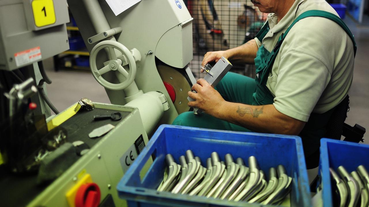 Ein Angestellter der Firma Biomet schleift an Hüftprothesen in einer Werkstatt des Unternehmens in Berlin (hier eine Aufnahme vom 04.08.2010)