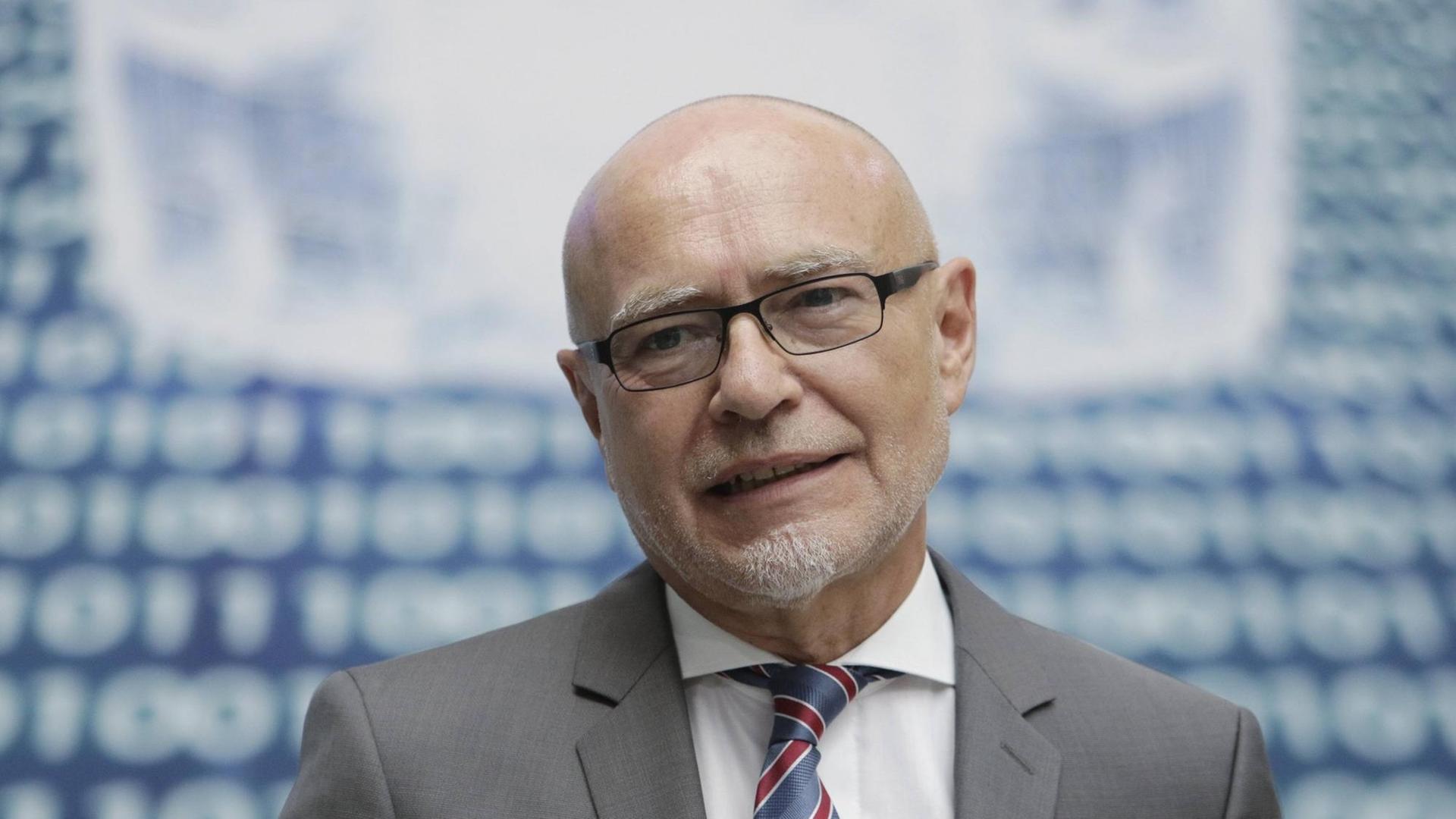 Das Bild zeigt einen lächelnden Udo Di Fabio mit Brille, Kinnbart, Krawatte und Anzug.