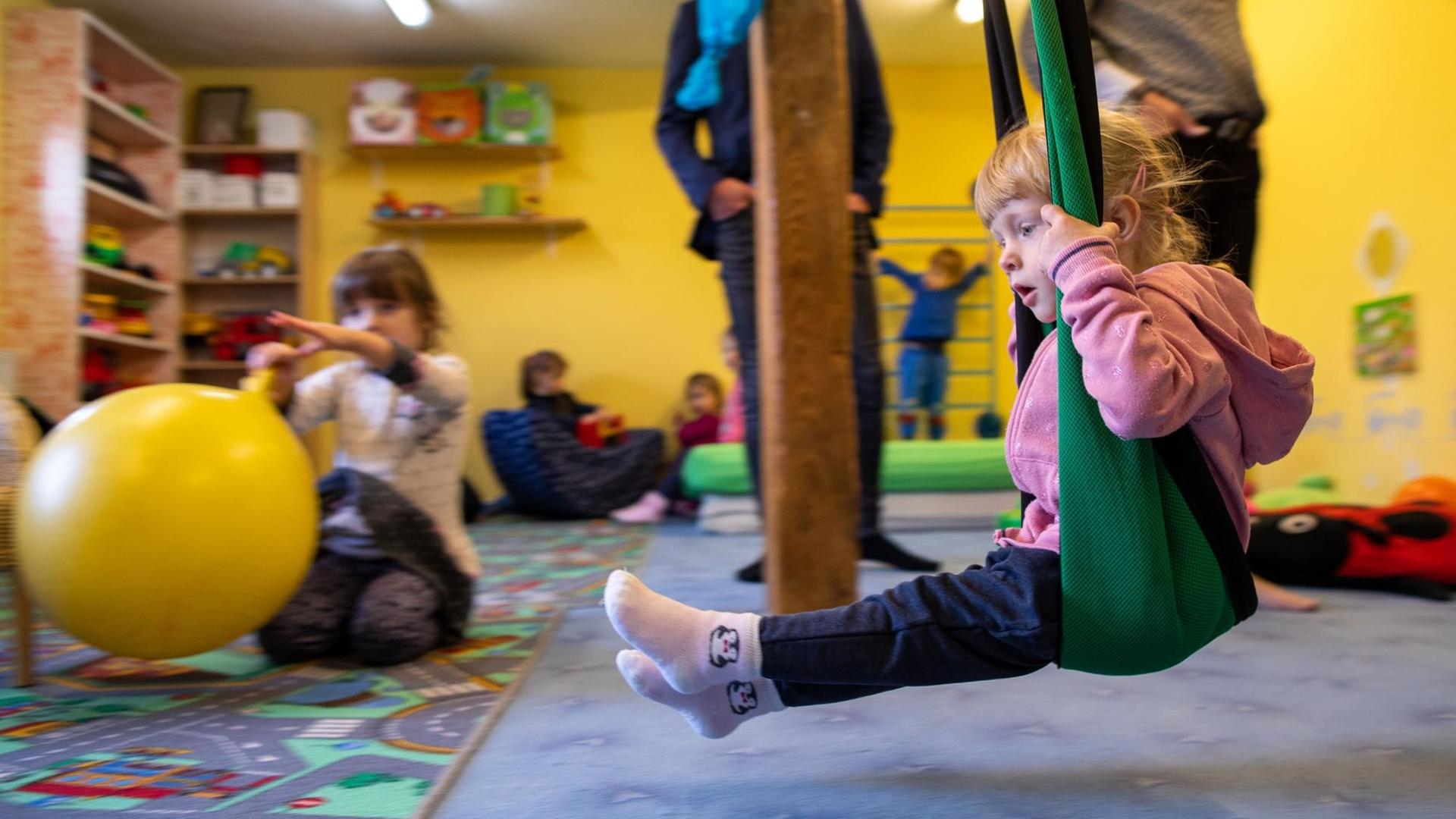 Die kleine Lina tobt in der Kindertagespflegeeinrichtung "Mausekind & Hase" im Spielzimmer.