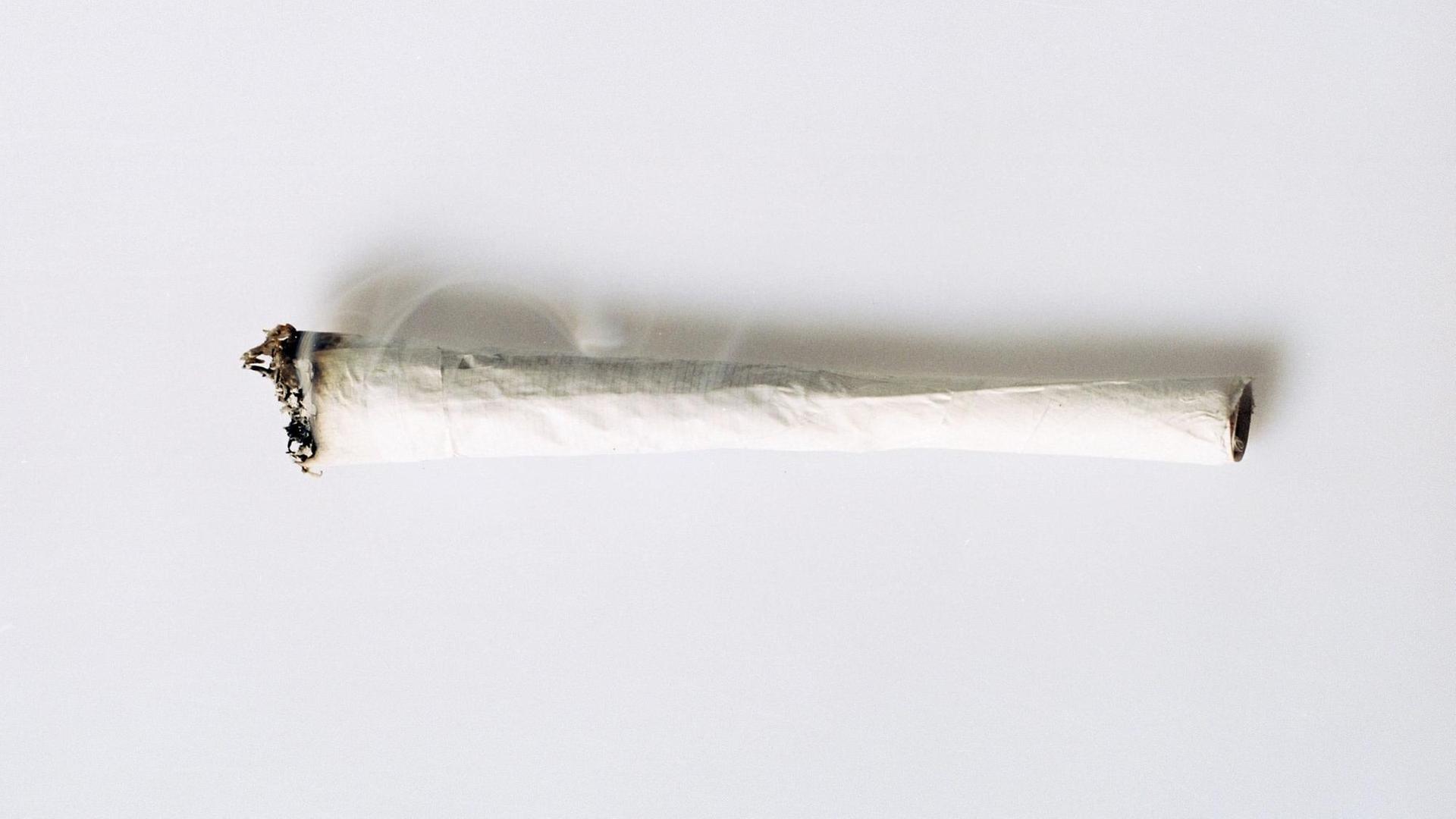 Eine Haschisch-Zigarette (Joint) liegt auf einer weißen Fläche.