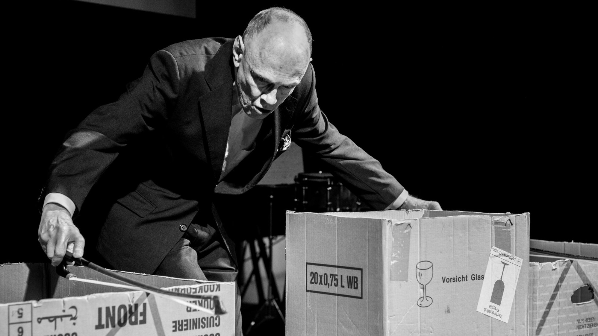 Sven-Åke Johansson streich mit dem Bassbogen Pappkartons