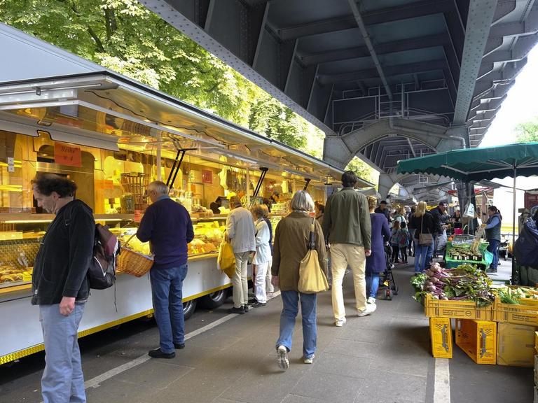 Der Isemarkt in Hamburg, der längste Wochenmarkt in Deutschland. Die U-Bahn-Gleise schützen vor Regen.