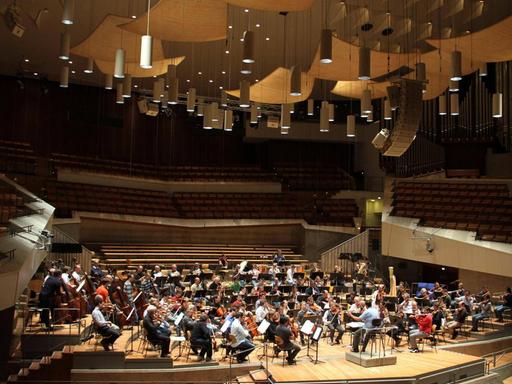 Das Orchester befindet sich auf der Bühne der Berliner Philharmonie, die Ränge sind leer. Das Orchester befindet sich auf der Bühne der Berliner Philharmonie, die Ränge sind leer.