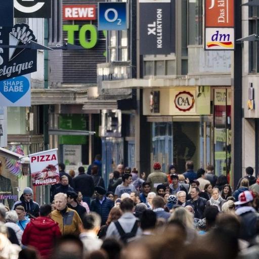 Passanten auf der Hohe Straße in Köln, im Hintergrund sind die Schilder vieler Geschäfte zu sehen, aufgenommen im Mai 2018.