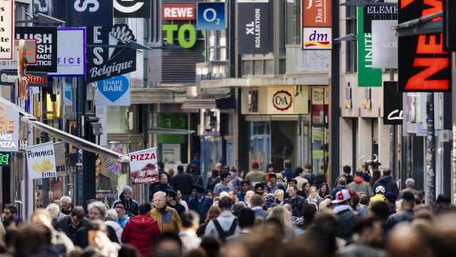 Passanten auf der Hohe Straße in Köln, im Hintergrund sind die Schilder vieler Geschäfte zu sehen, aufgenommen im Mai 2018.