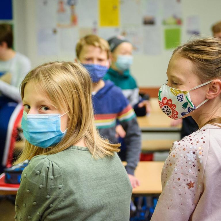 Schülerinnen und Schüler einer sechsten Klasse der Max-Planck-Schule Kiel warten in ihrem Klassenzimmer auf den Unterrichtsbeginn und tragen dabei einen Mund-Nasen-Schutz.