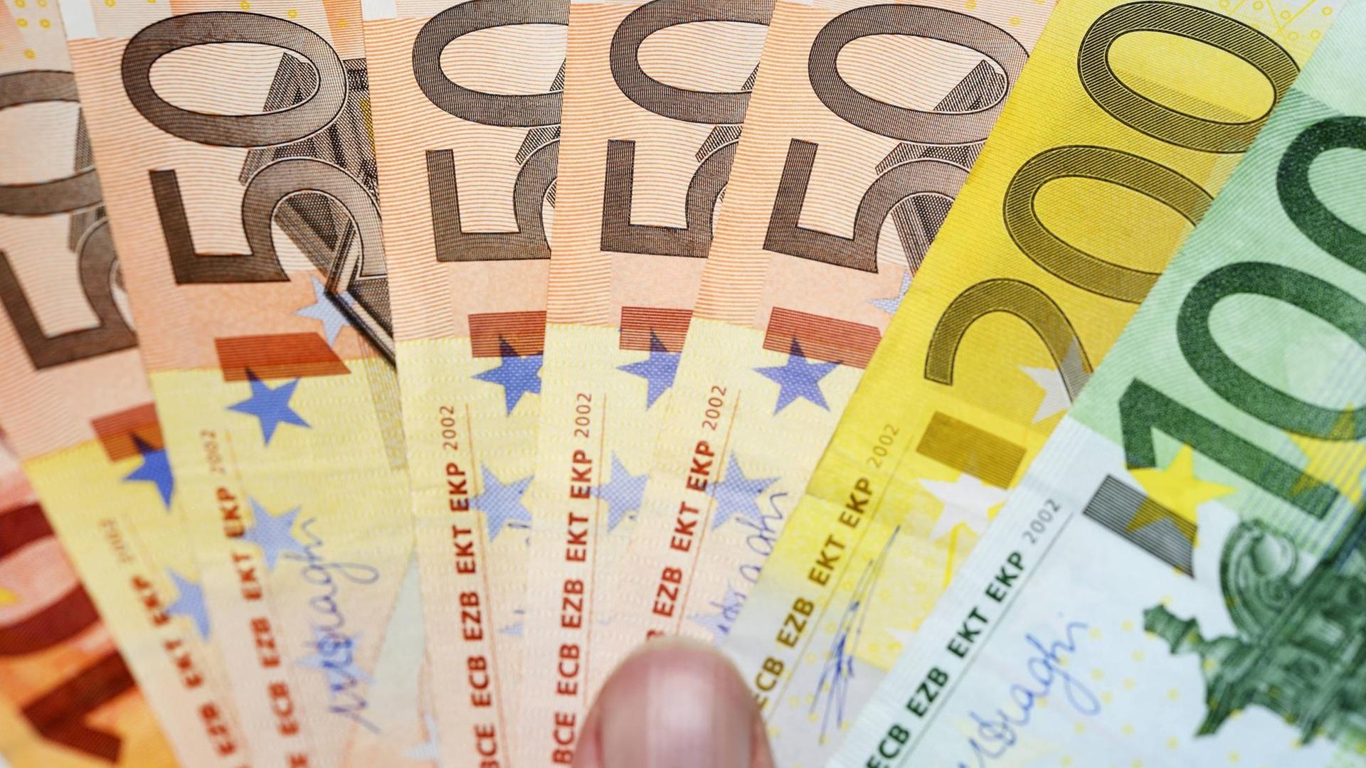 Eine Hand hält Euro-Geldscheinwie einen Fächer. | Verwendung weltweit