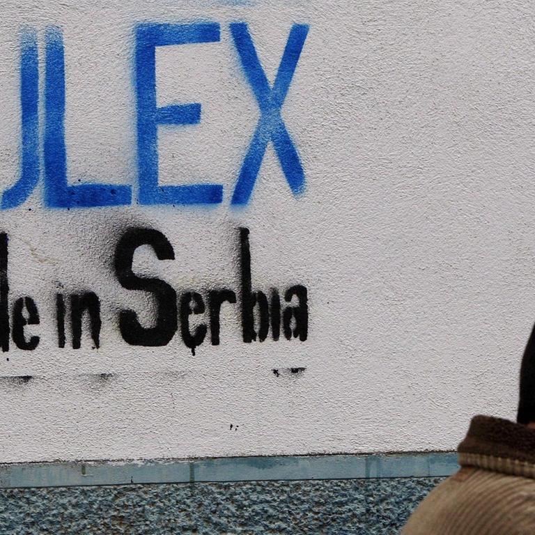 Ein kosovo-albanischer Mann geht am 28. November 2008 in Pristina, Kosovo, vorbei an einem Graffiti mit der Aufschrift "EULEX Made in Serbia".