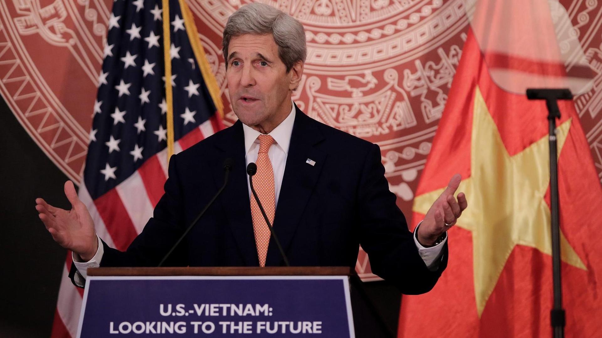 US-Außenminister Kerry bei einer Rede in der vietnamesischen Hauptstadt Hanoi, im Hintergrund die Flaggen der USA und Vietnams.