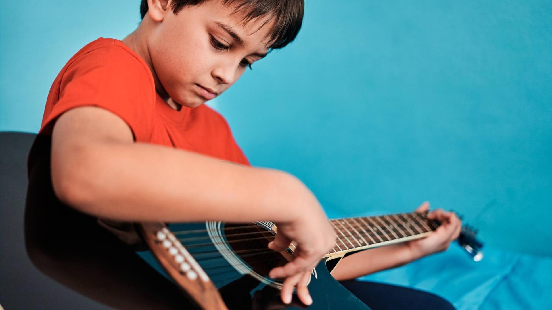 Ein Junge an einer Gitarre
