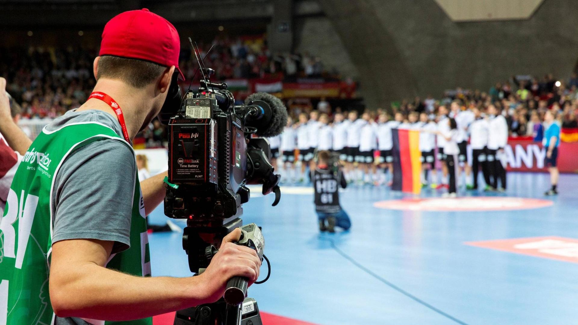 Ein Kameramann filmt das Geschehen auf dem Feld vor dem Handballspiel Deutschland - Daenemark