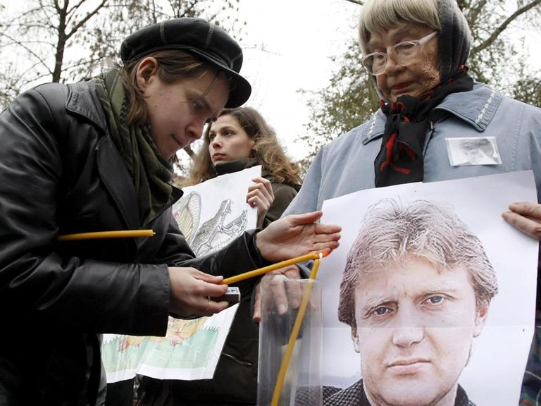 In Moskau zünden Menschenrechtsaktivisten zum Gedenken an den ermordeten ehemaligen KGB-Mann Alexander Litwinenko Kerzen an und halten ein Porträt des Regimekritikers hoch.
