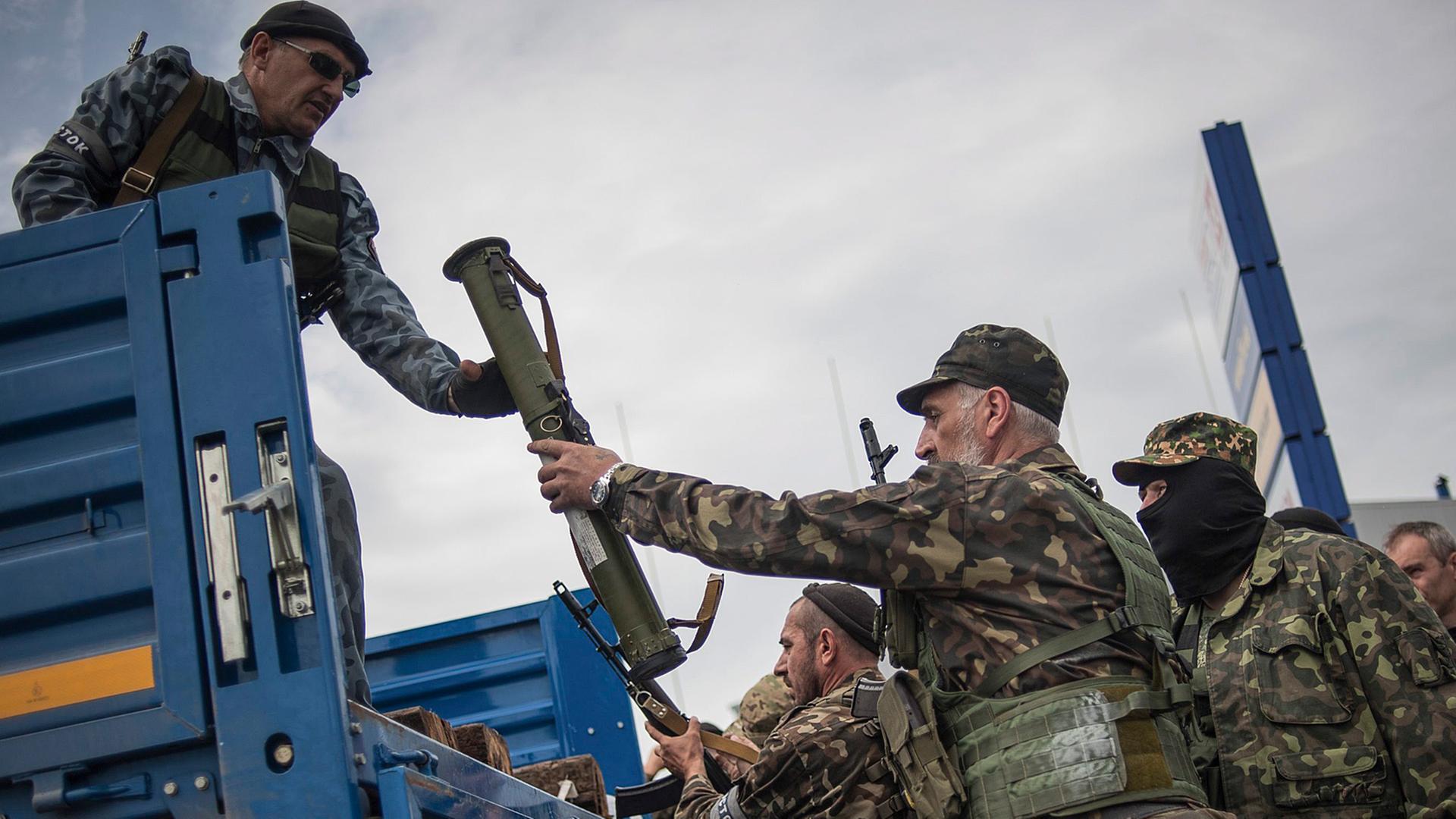 Pro-russische Aktivisten laden Waffen auf einen Truck, nachdem sie sich Gefechte mit ukrainischen Soldaten vor Donetsk geliefert haben.