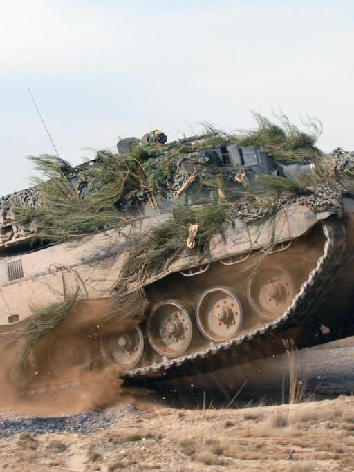Kampfpanzer vom Typ Leopard 2 in voller Fahrt auf einem Testgelände