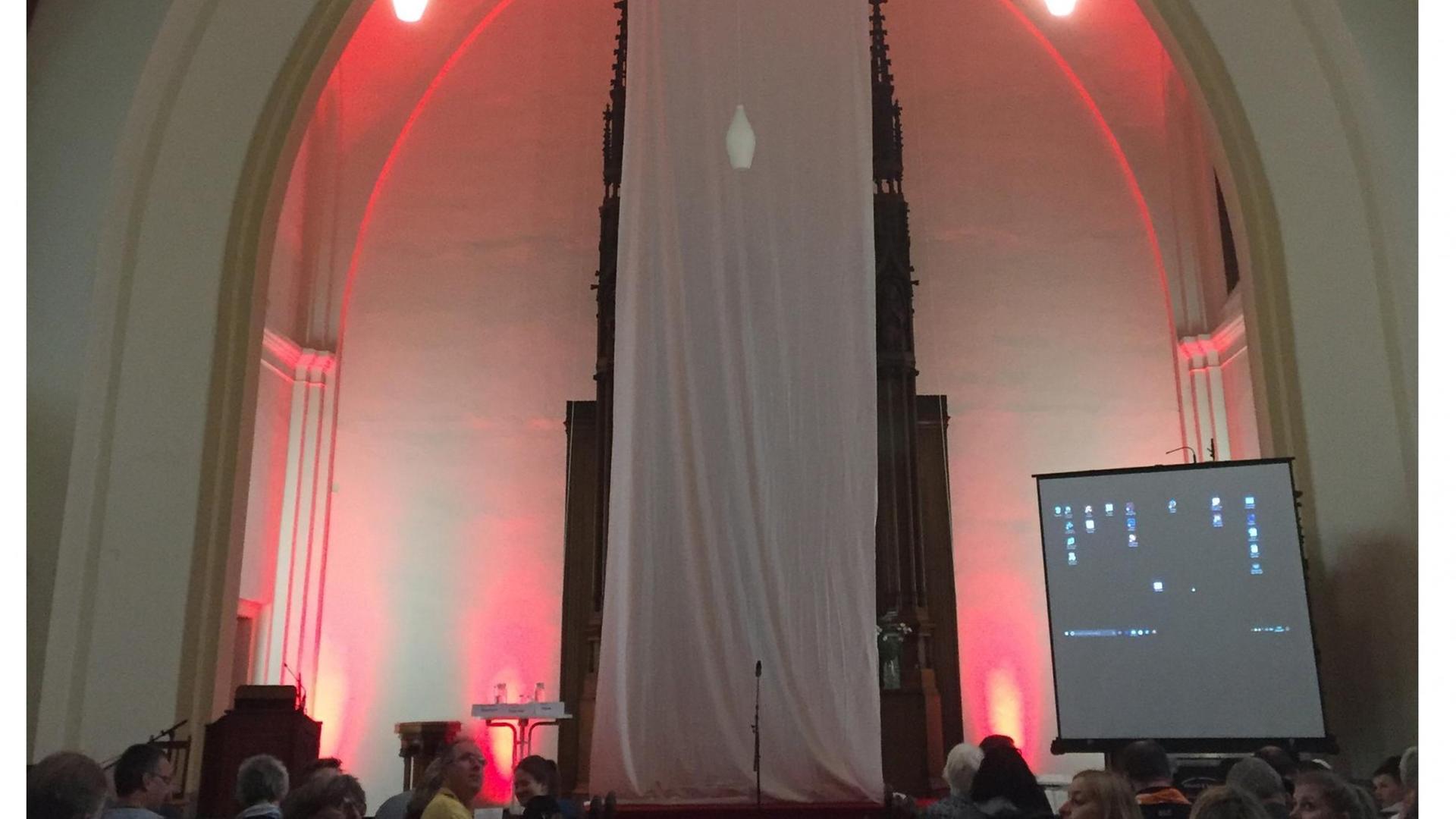 Christlich-islamischer Gottesdienst in Berlin - ein langes weißes Tuch verdeckt den Altar