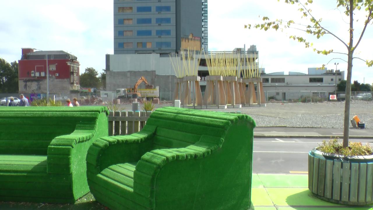 Ein grüner Sessel in Christchurch vor einer Brachfläche
