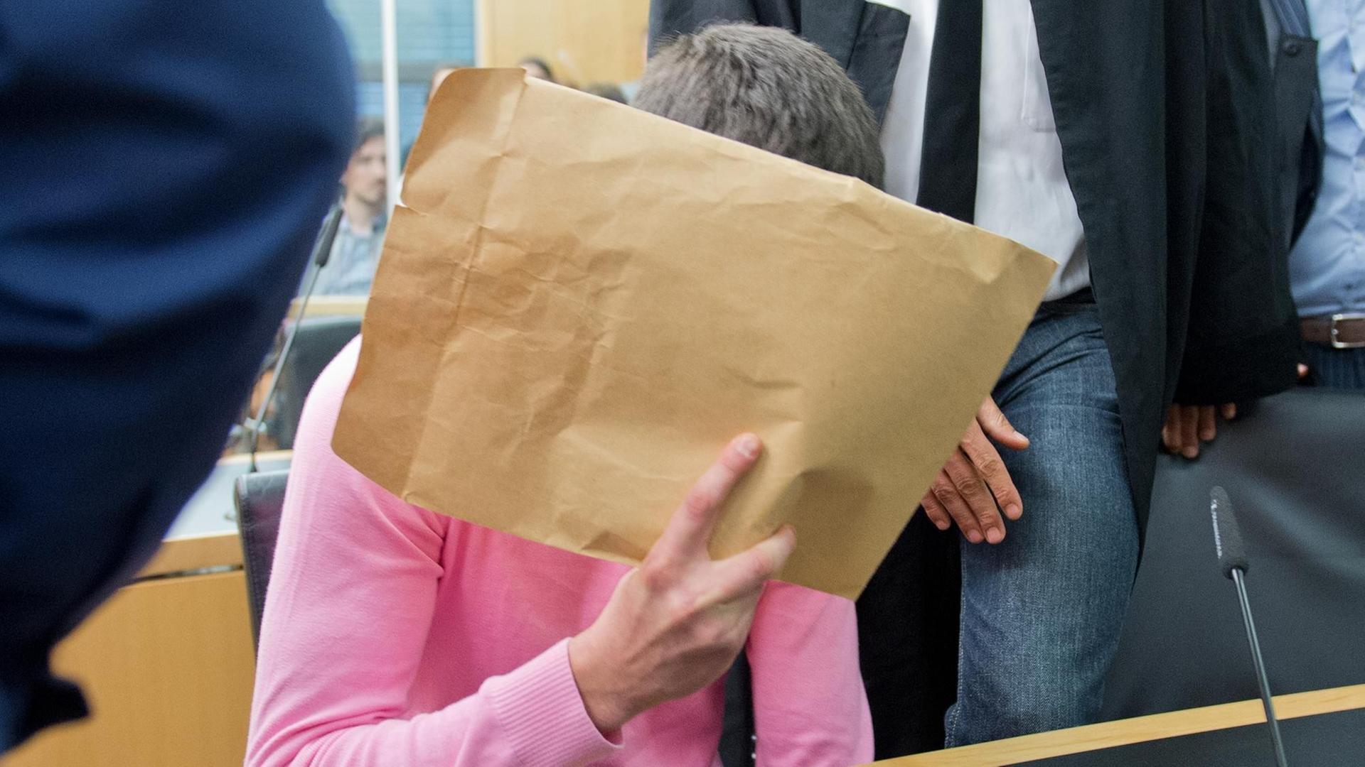 Der Täter verbirgt sein Gesicht hinter einem großen Brief-Umschlag.