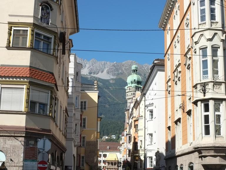 Blick durch eine Gass in Innsbruck auf das Wahrzeichen der Stadt, das 'Goldene Dachl'