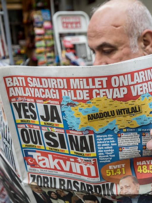 Ein Mann liest am 17.04.2017 in Istanbul in der Türkei die Zeitung Takvim auf der in mehreren Sprachen die Zustimmung zum Referendum beschrieben wird. Die Türken stimmten knapp mit "Evet" (JA) zu einer Verfassungsänderung zur Einführung eines Präsidialsystems, das Staatspräsident Erdogan mehr Macht verleiht.