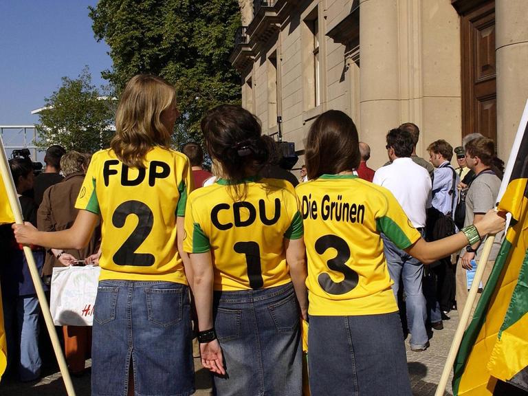 In Berlin wird über eine Jamaika-Koalition verhandelt: Parteien FDP, CDU und DIE GRÜNEN auf T-Shirts dreier Mädchen mit Fahnen in Berlin