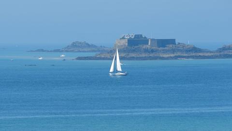 Ein Segelschiff kreuzt zwischen den Felsinseln vor der Altstadt von Saint-Malo, aufgenommen am 04.09.2013. Foto: Thomas Muncke