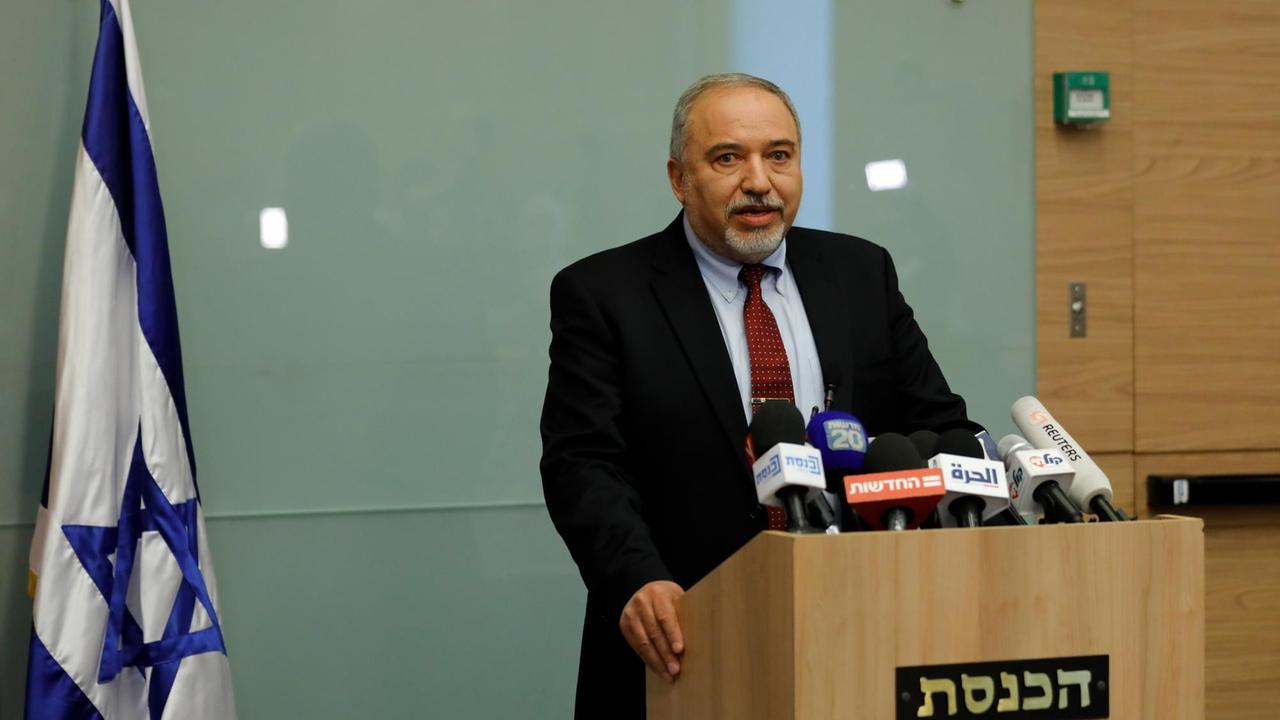 Avigdor Lieberman steht an einem Rednerpult vor einer israelischen Flagge.