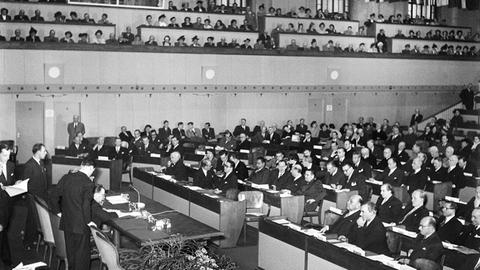 Ein Schwarz-Weiß-Foto zeigt Vertreter der Staaten Ägypten, Afghanistan, Argentinien, Österreich, Bolivien, Brasilien, Kanada, Spanien, USA, Finnland, Frankreich, Ungarn, Israel, Italien, Luxemburg, Niederlande, Polen, England, Vatikan, Schweden - sie treffen sich am 12. August 1949 in Genf zur Unterzeichnung der vier Genfer Konventionen.