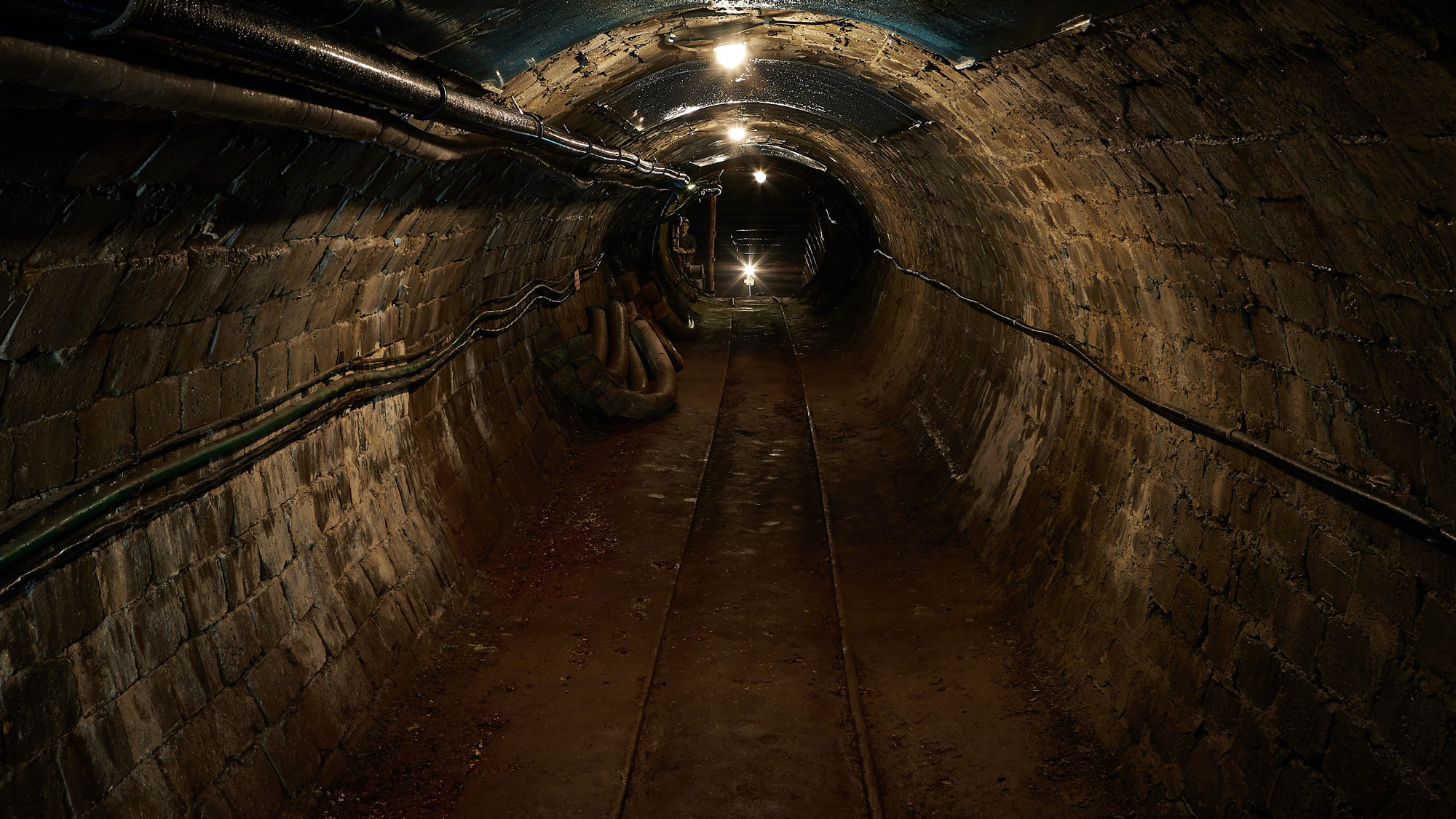 Ein beleuchteter Tunnel mit Gleisen.