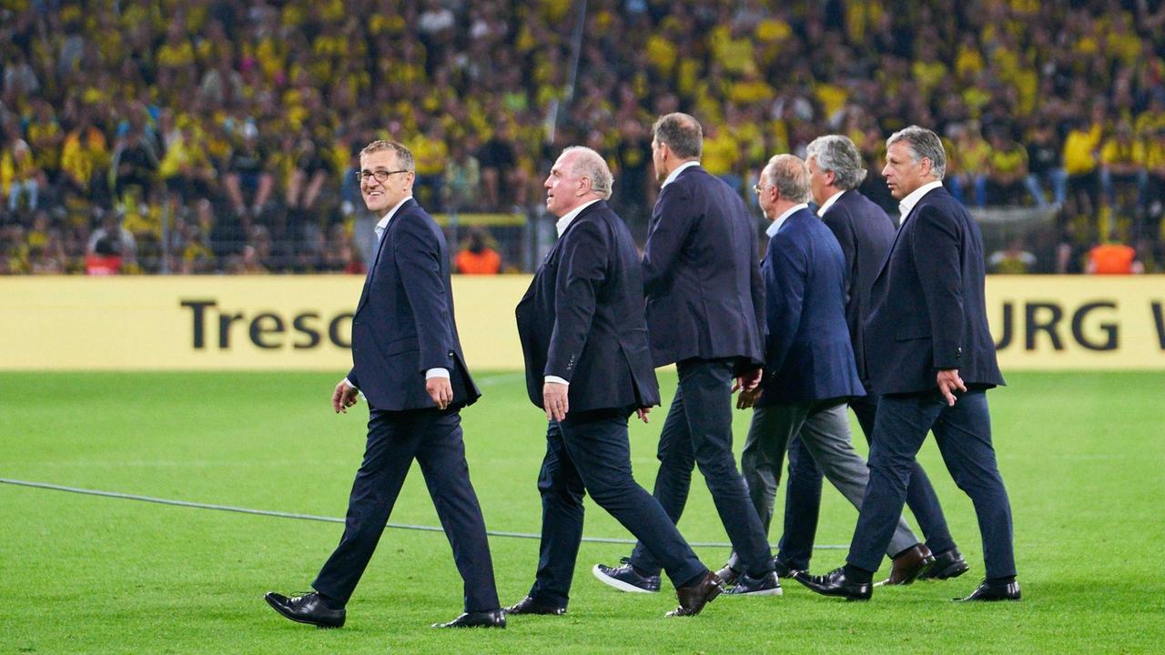 Führungsriege des FC Bayern läuft über das Spielfeld im Signal Iduna Park in Dortmund.