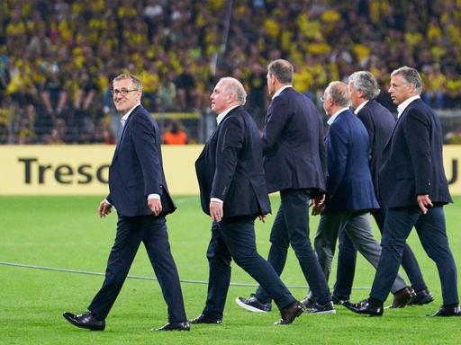 Führungsriege des FC Bayern läuft über das Spielfeld im Signal Iduna Stadion.