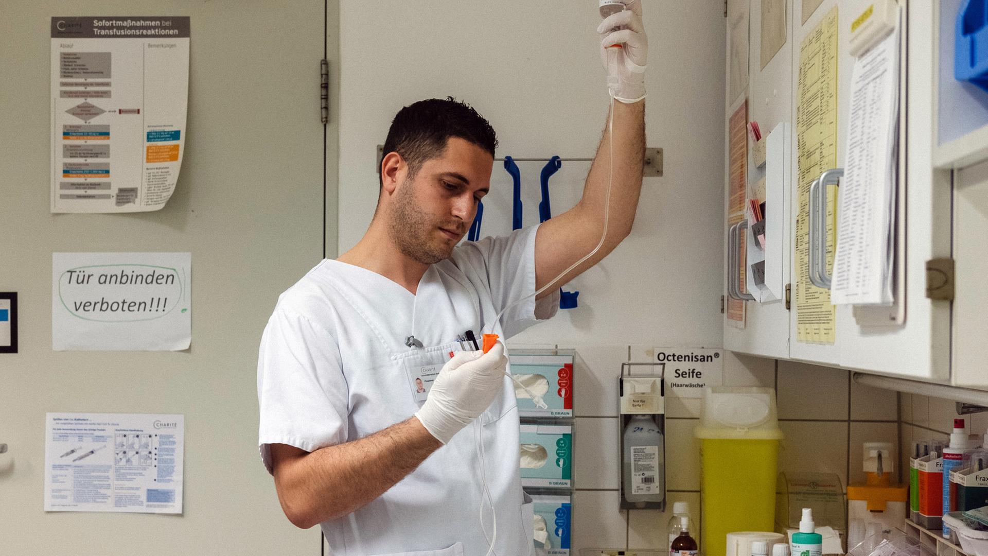 Der albanische Krankenpfleger Samed Qoshja bereitet in der Neurochirurgie der Charité am Campus Benjamin Franklin eine Infusion vor.