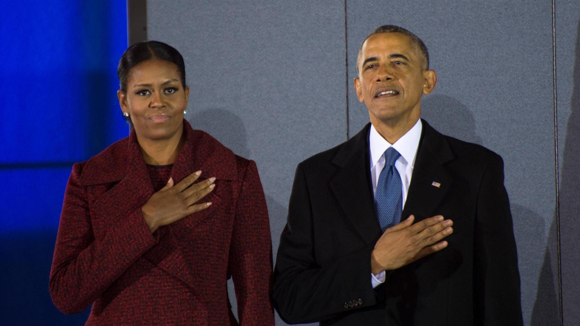 Der frührere U.S. Präsident Barack Obama und First Lady Michelle Obama stehen am 20. Januar 2017 während der Nationalhymne vor der Militärbasis Joint Base Andrews in Maryland
