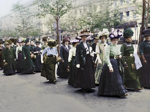 Eine Gruppe von Demonstrantinnen für das Frauen-Wahlrecht im Mai 1912 in Berlin auf dem Weg zum Versammlungsort. | Foto Gebr. Haeckel / picture alliance; digital koloriert Eine Gruppe von Demonstrantinnen für das Frauen-Wahlrecht im Mai 1912 in Berlin auf dem Weg zum Versammlungsort. | Foto Gebr. Haeckel / picture alliance; digital koloriert