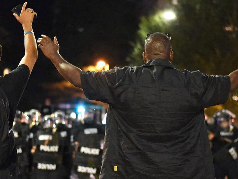 Protestierer mit erhobenen Händen stellen sich Polizisten entgegen: In Charlotte im US-Bundesstaat North Carolina hatten Polizeibeamte am 21. September 2016 den Afroamerikaner Keith Lamonth Scott erschossen.